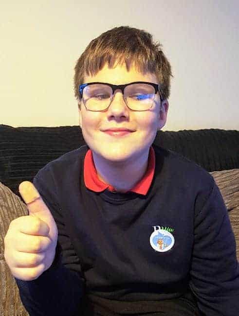Ben showing a plaster on his thumb and a sticker