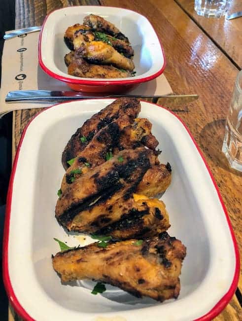 Chicken wings in red and white dish at Smoky Boys in Watford