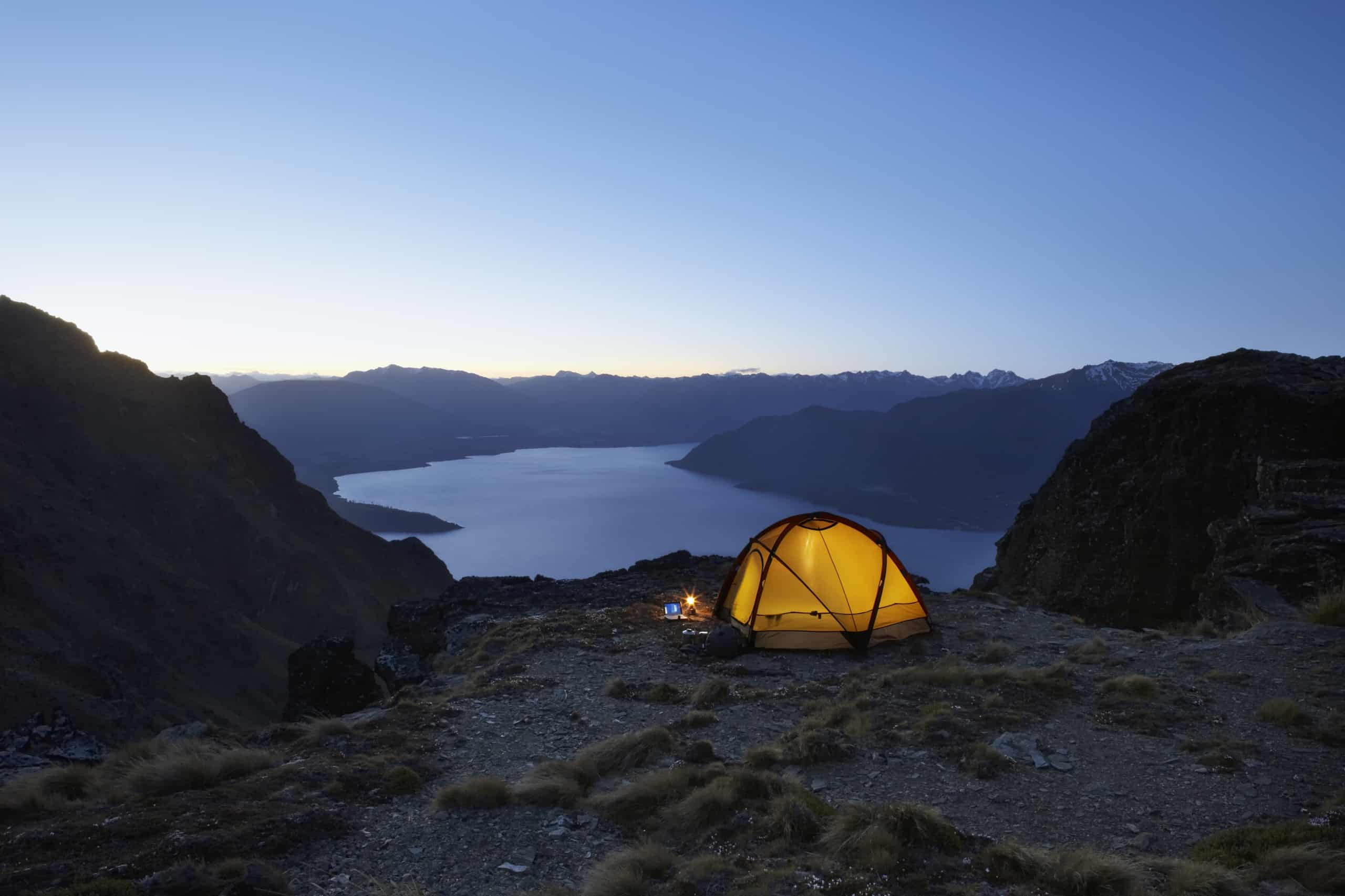 A yellow tent camped up by the water