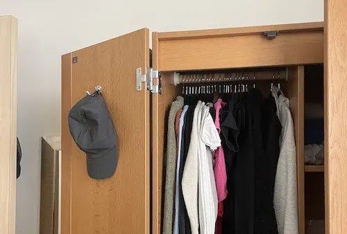 Clothes hung in a small dorm closet