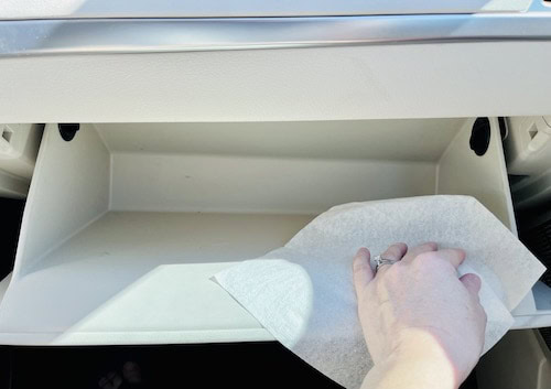 To organize a glove box, first take everything out and wipe down the interior.