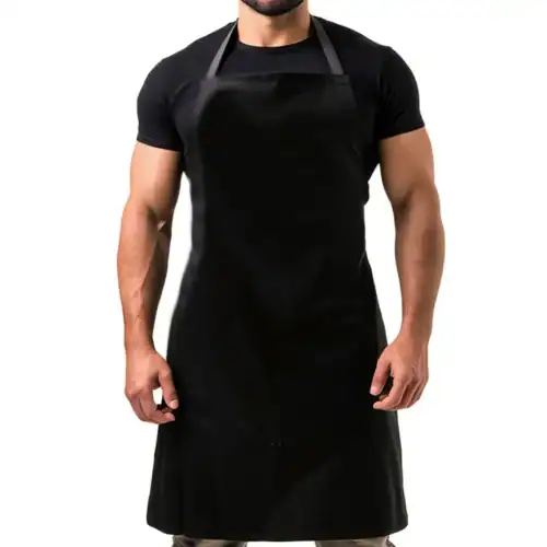Basic Cotton Canvas Apron in Black, studio front view, person wearing