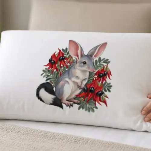 Lifestyle photo of the Bilby Among Sturt Desert Peas Pillow Case being worn or used