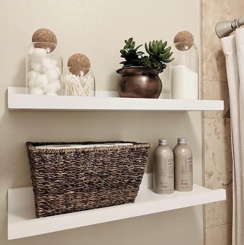 Small bathroom organizing: floating shelves add storage space for bathroom essentials.