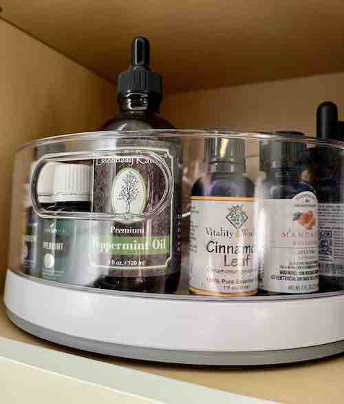 Essential oil bottles stored on a Lazy Susan in a cabinet