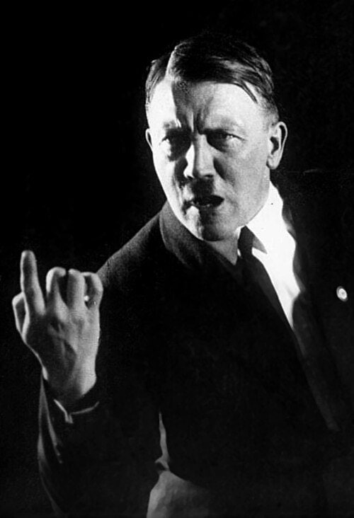 Img: Adolf Hitler in 1927 terwijl hij zijn oratorische gebaren oefent tijdens een repetitie voor politieke toespraken. Adolf Hitler in 1927 tijdens een oefensessie waarin hij zijn spreekgebaren en lichaamshouding voor politieke toespraken repeteert