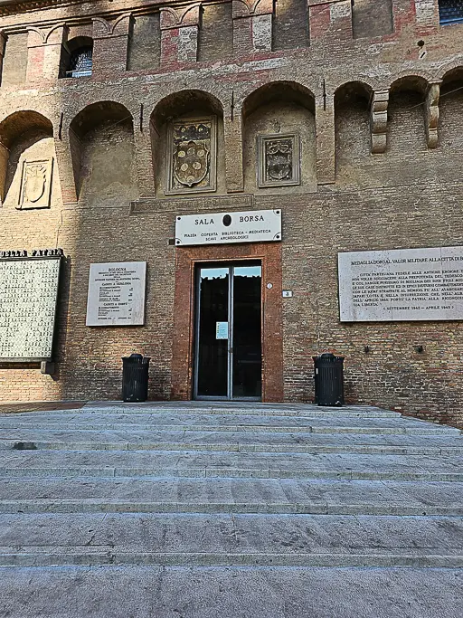 Main entrance to Bologna’s Sala Borsa Civic Library with historical plaques and medieval coat-of-arms—great for documenting Bologna’s literary and civic history.
