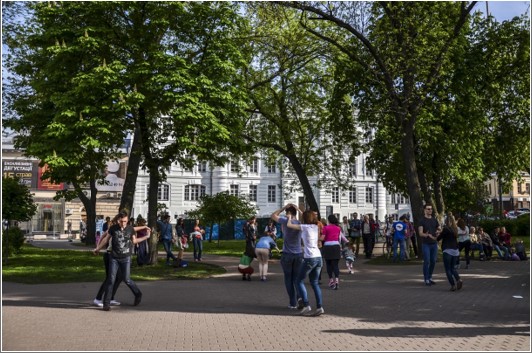 An outdoor event with people dancing in a park.