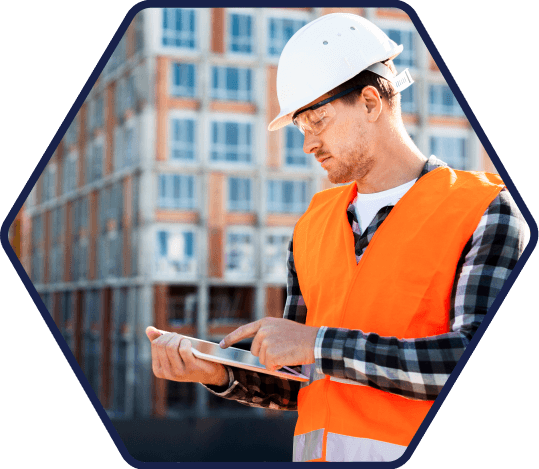 Construction worker looking at a tablet, in a hexagon frame.