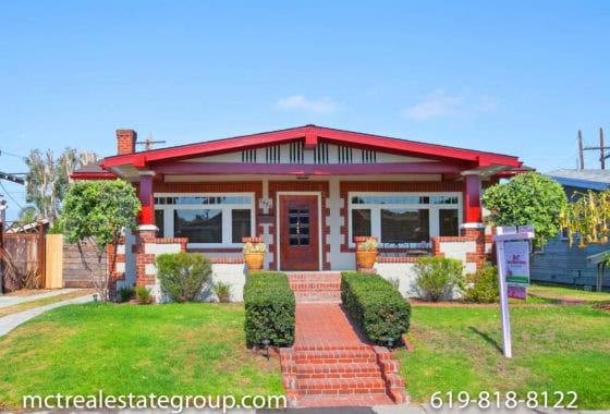 Craftsman-style home at 3686 28th Street in North Park featuring a distinctive red painted porch and trim, decorative brick pillars, and a red brick pathway leading to the front door.