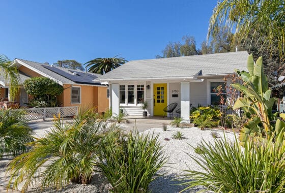 Front exterior of a home featuring a bright yellow door and landscaped front yard at 3750 Arizona Street in North Park.