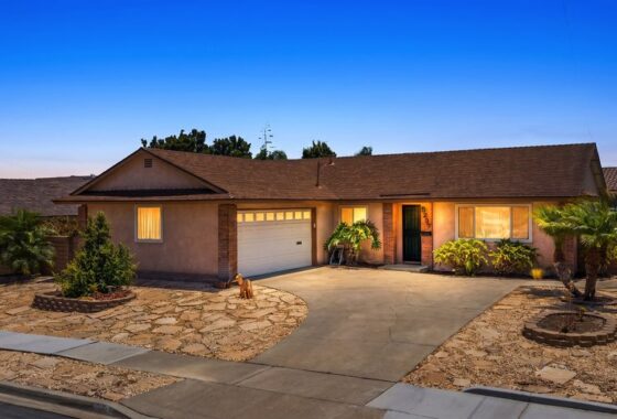 Single-story house with a brown shingle roof, tan stucco walls, and a concrete driveway leading to a white garage door at 5237 Diane Ave in Clairemont.
