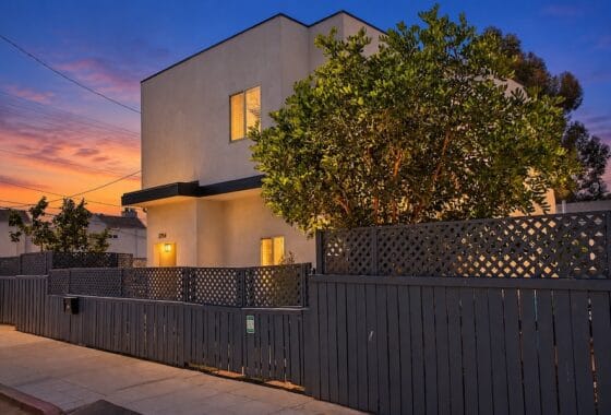 Dusk exterior view of the front facade, privacy fencing, and surrounding landscaping at 3754 Alabama Street in North Park during sunset.