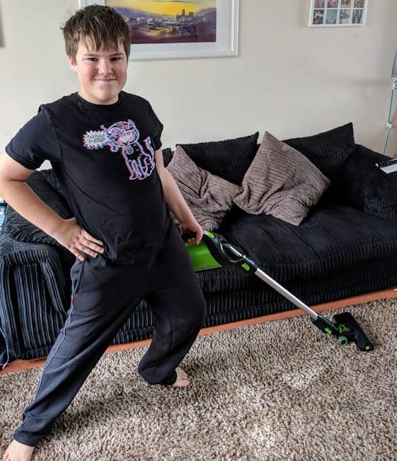 Young boy hoovering a carpet