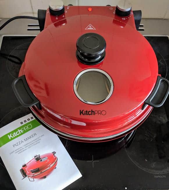 Red Kitchpro pizza oven with instructions.
