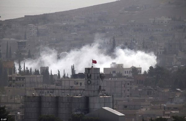Horror: Fighting continues to rage between Islamic State militants and Kurdish forces in besieged Syrian city of Kobane (pictured)
