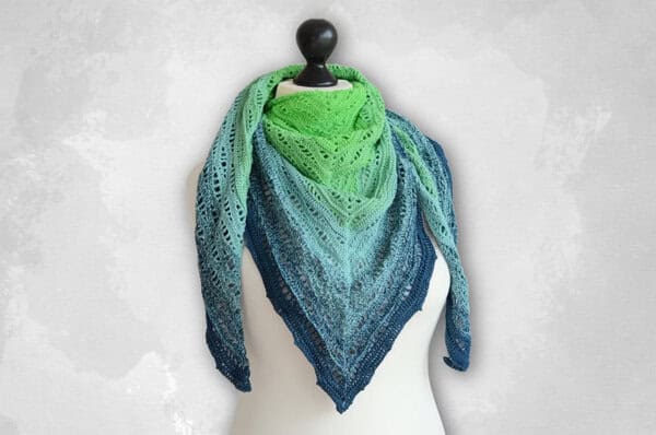 Gehäkeltes Dreieckstuch in Blau-Grün mit Reliefmaschen, als Halstuch getragen.