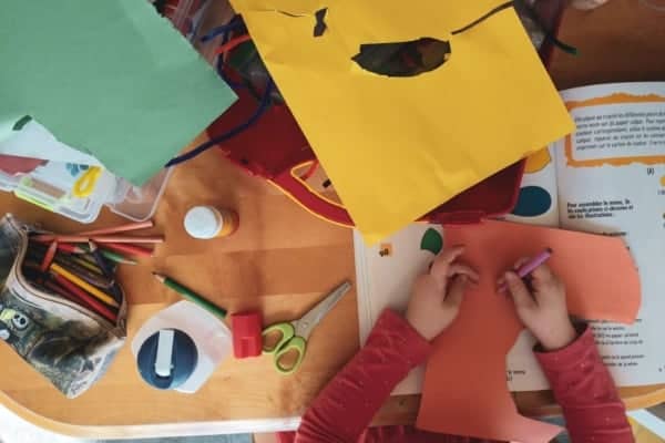 child writing and cutting paper