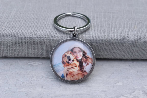 Runder Schlüsselanhänger mit einem Foto von einer Frau und einem Hund