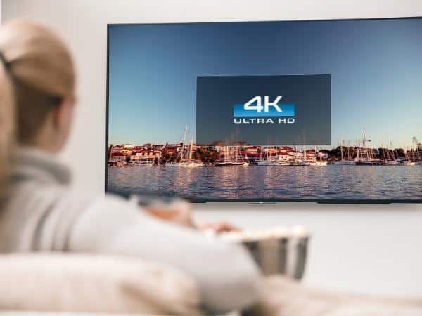 Blonde lady watching a 4k TV.