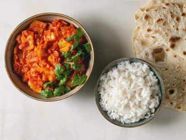 cooked jackfruit in a curry with tice and naan bread