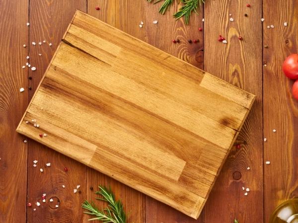 chopping board with crumbs and ground salt around it.