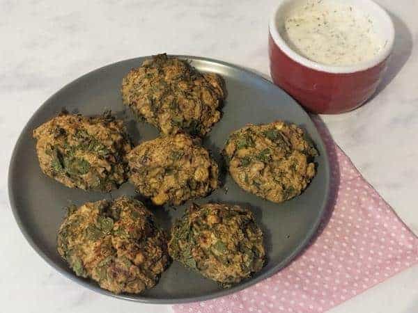 falafel on a grey plate with red ramekin of white coloured dip