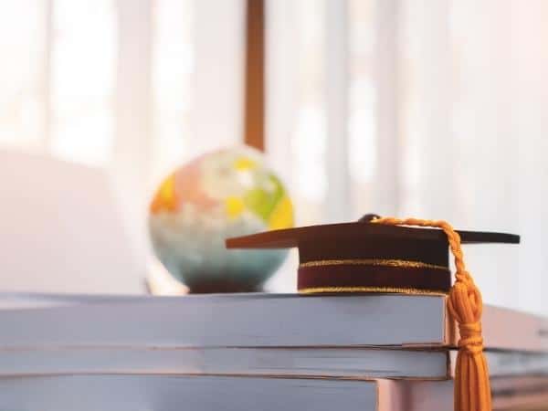 A close up of a globe and graduation cap