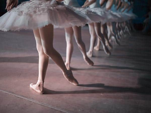 A line of ballet dancers in tutus