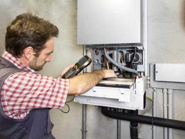 a man with boiler installed and fixing last bits into it