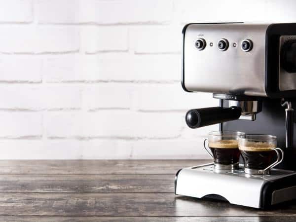 Espresso and Coffee Maker with two glasses of ready to drink black coffee.