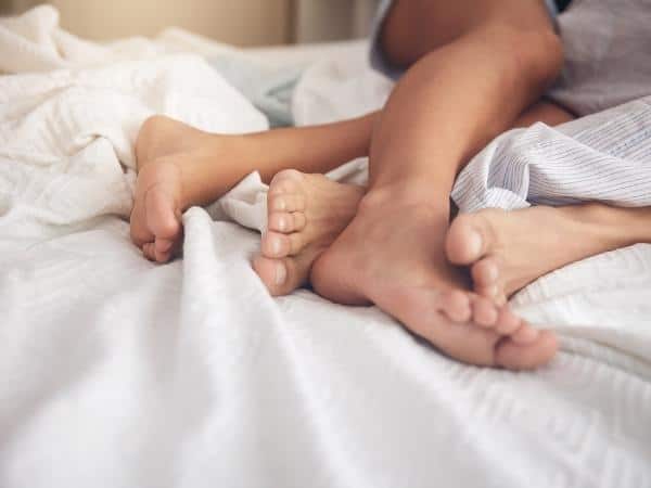 couple in bed with feet over each other