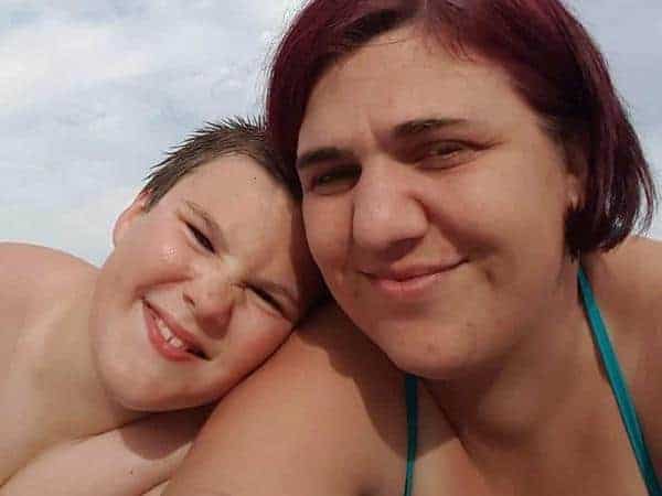 Jen smiling with Ben on the beach