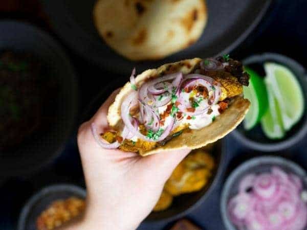 hand holding roti with spiced cauliflower