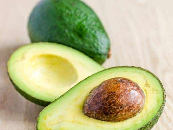 Closeup of avocados on wooden background