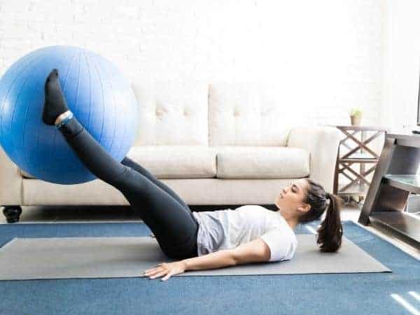 lady using exercise ball whilst watching tv