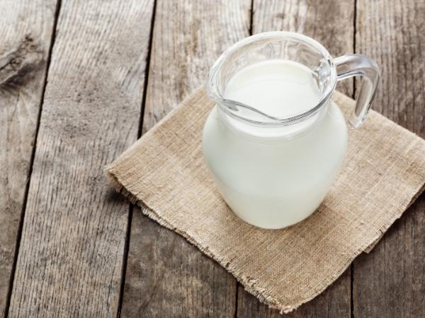 A jug of milk sitting on top of a wooden table