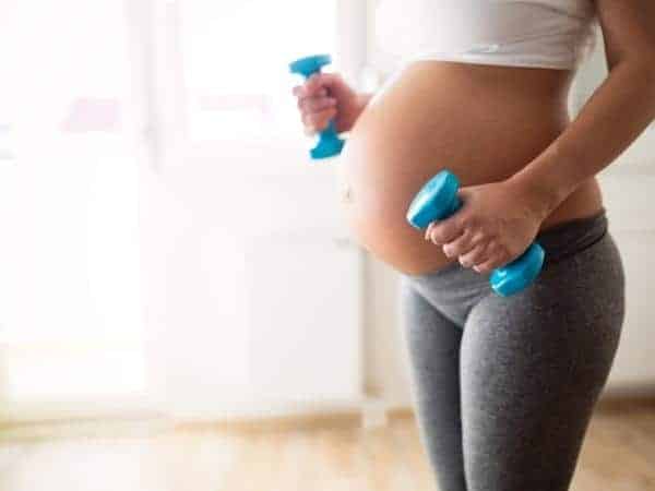 pregnant lady holding small blue weights in each hand