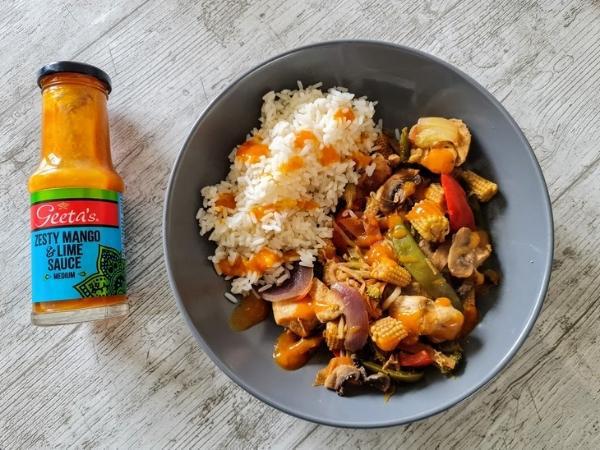 A plate of stir fry on a table, with Rice