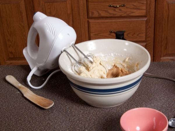 A bowl of icecream with whisk on a table
