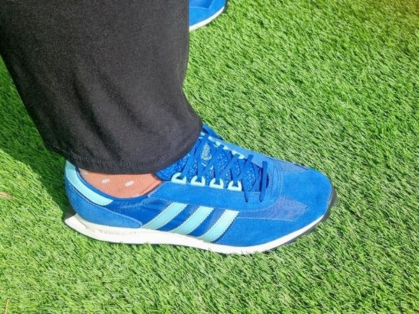 teal blue adidas trainers on artificial grass