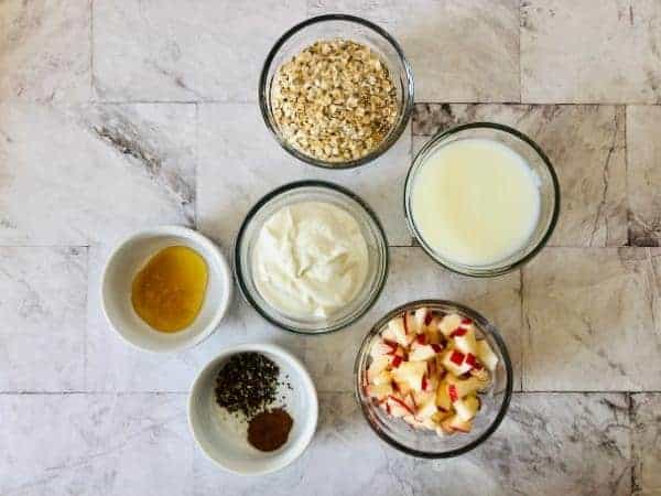 ingredients needed for overnight apple and cinnamon oats with apple, yoghurt, oats, cinnamon, milk and other ingredients.