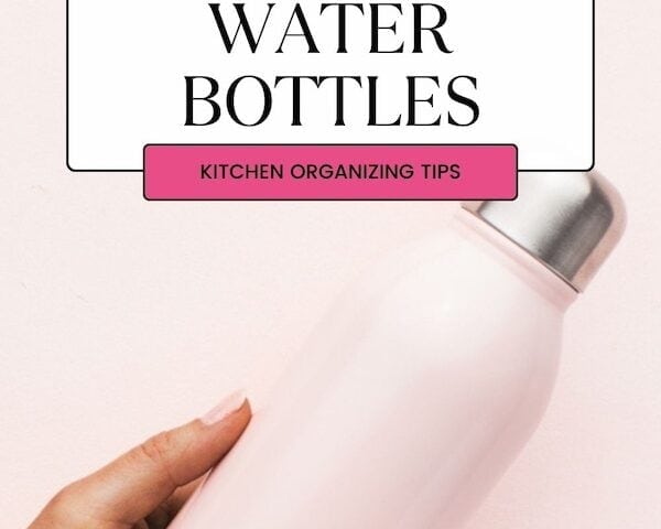 woman holding a pink reusable water bottle against pink background