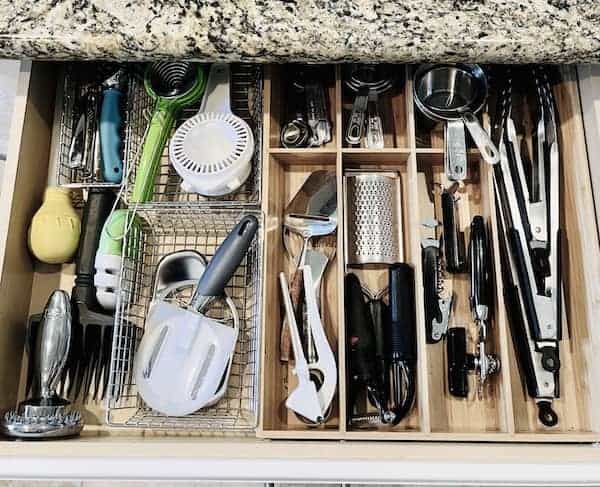 A kitchen utensil drawer with utensils in drawer organizers