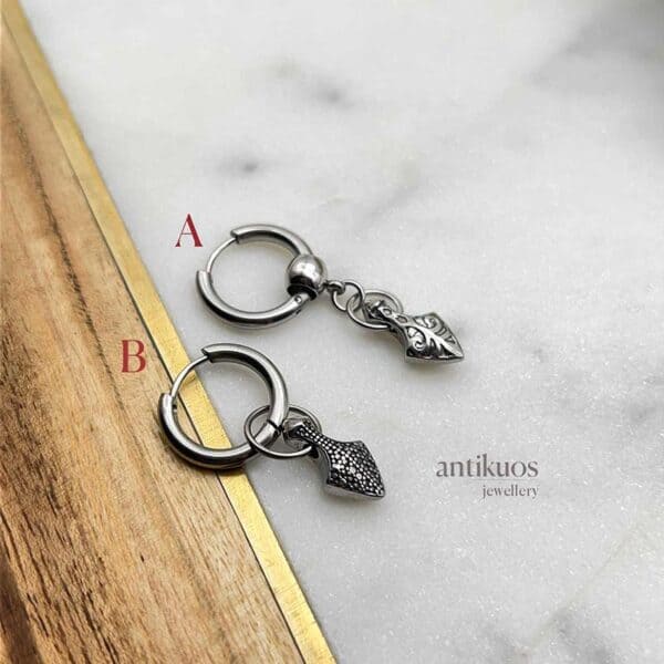 Small arrow stainless steel biker earring by Antikuos jewellery, close-up