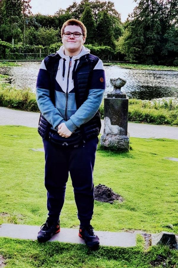 Teenage boy posing for photo in front of water