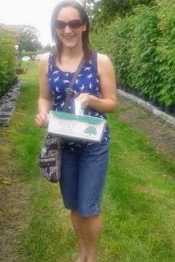 Claire in blue clothing collecting strawberries