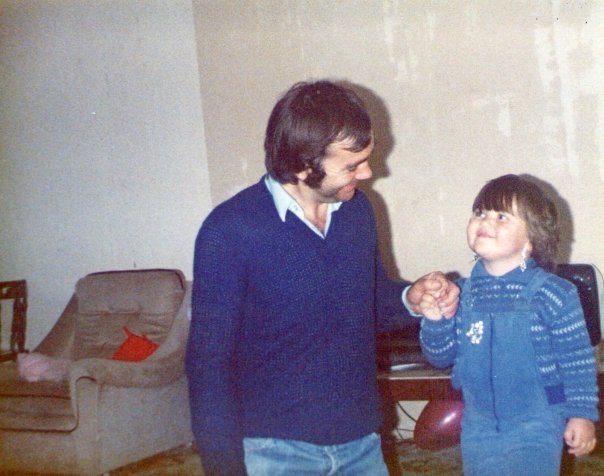Young girl looking up at her father and smiling