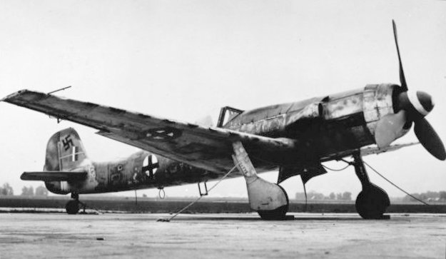 Focke-Wulf Ta 152 op vliegveld tijdens WW2 Focke-Wulf Ta 152 geparkeerd op een vliegveld, met duidelijk zichtbare verlengde vleugels en staart, klaar voor een testvlucht.