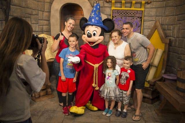 A multi-generational family poses with Sorcer Mickey Mouse at Red Carpet Dreams in Disney's Hollywood Studios
